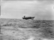 Asisbiz RN escort carrier HMS Biter in rough weather with Hurricanes tied down on her flight deck IWM A12578