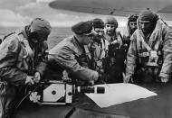 Asisbiz Heinkel He 111 bomber discussing their aims over a map IWM HU76019