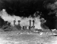 Asisbiz USS West Virginia (BB 48) as burning oil drifts past the sunken battleship Pearl Harbor attack 7th Dec 1941 NH 94379