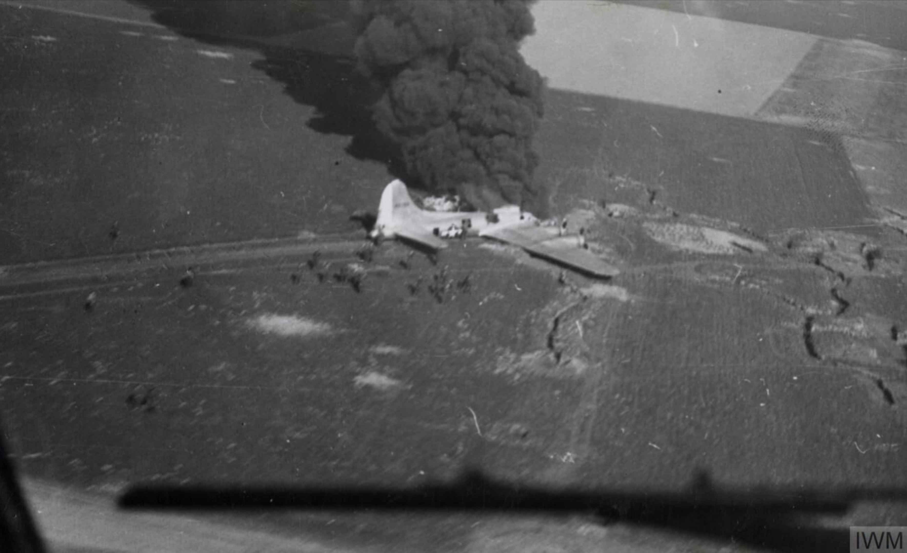 Boeing B-17 Fortress lies burning after belly landing after a raid on Orman airfields 1944 IWM FRE14224