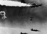 Asisbiz 8AF formations of B 17 Fortresses releases their bombs over Berlin with an engine on fire FRE11660