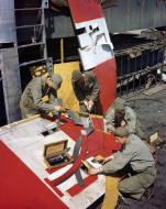 Asisbiz B-24 Liberator 8AF 466BG sheet metal workers mend a flak damaged rudder England 1944 01