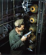 Asisbiz Ordanance guy inserts a fuse into a 100lb bomb in the bomb bay of a B-24 Liberator England 1944 01