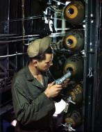Asisbiz Ordanance guy inserts a fuse into a 100lb bomb in the bomb bay of a B-24 Liberator England 1944 02
