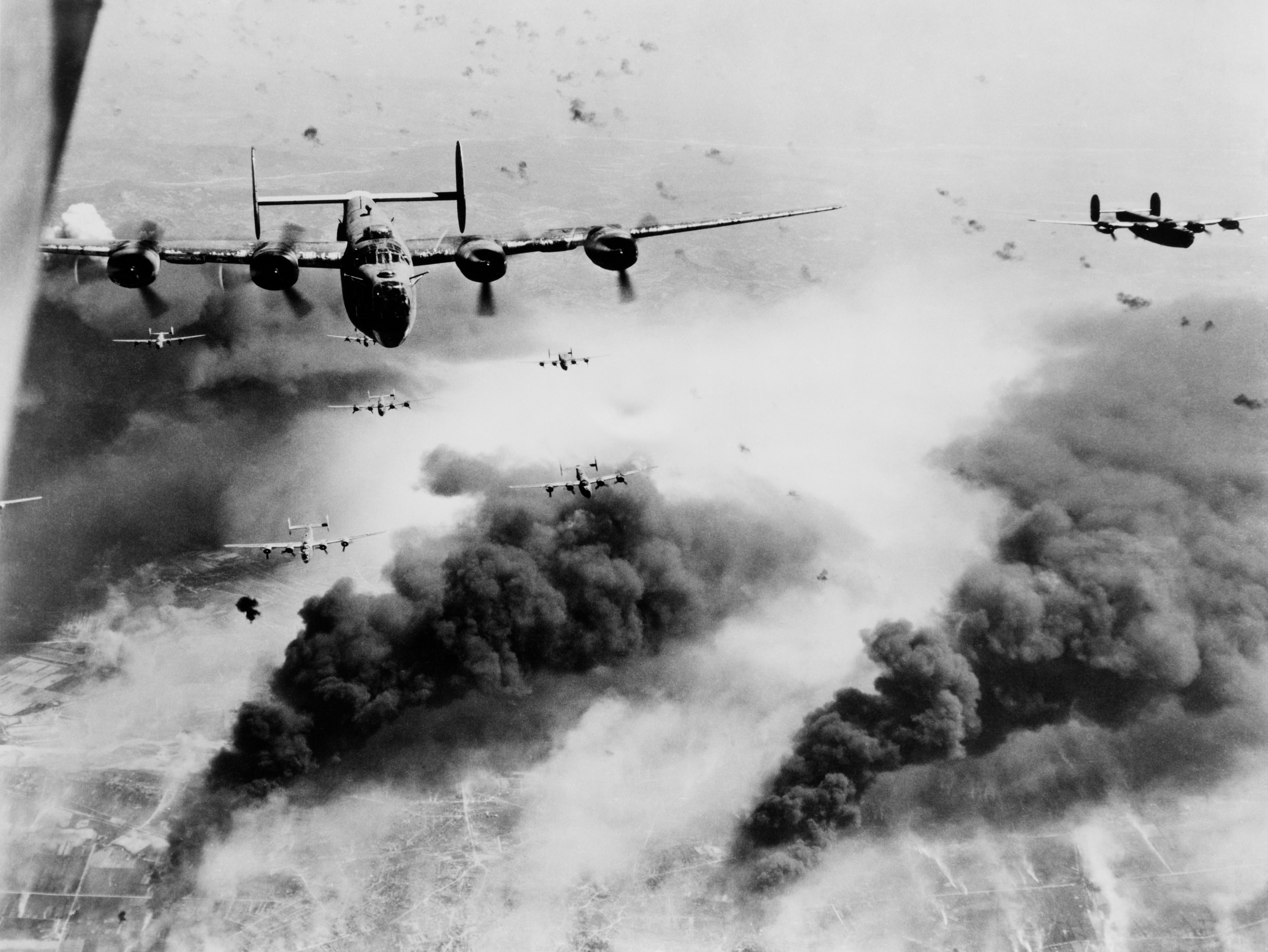 15th Air Force B-24s fly through flak and over the destruction created by preceding waves of bombers