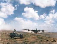 Asisbiz Airman in a jeep waves to a 9th Air Force B-24 Liberator crew taking off in North Africa 01