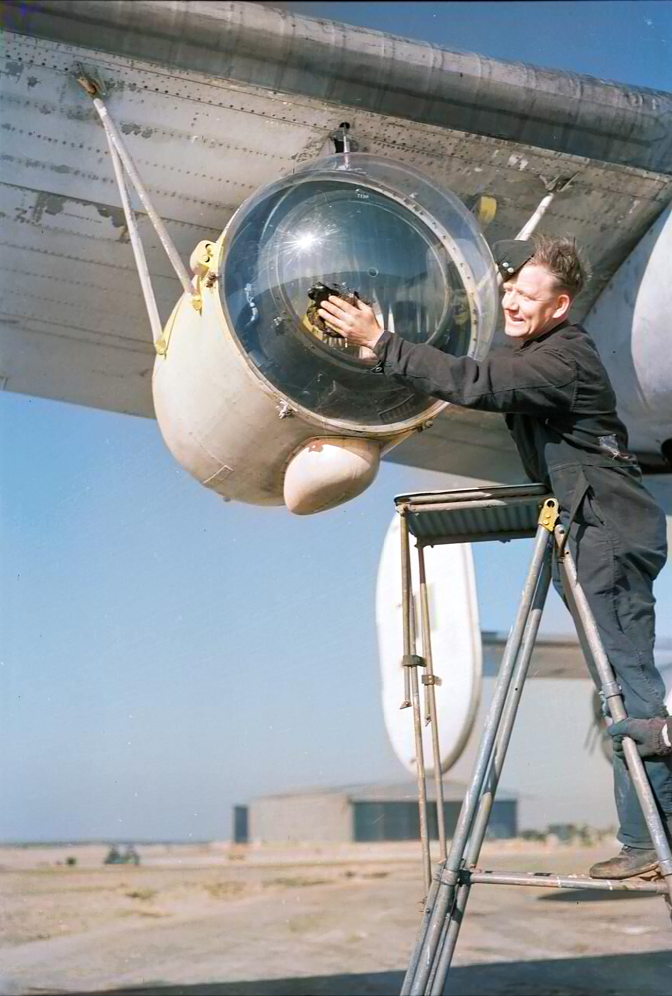 FMS Liberator GRV RAF ground crew member cleaning the plexiglass covering of a Leigh Light based at St Eval Cornwall 1944 IWM CH13997