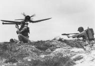 Asisbiz Ground support Corsair flies low over US Marines Okinawa Japan Apr 1945 01