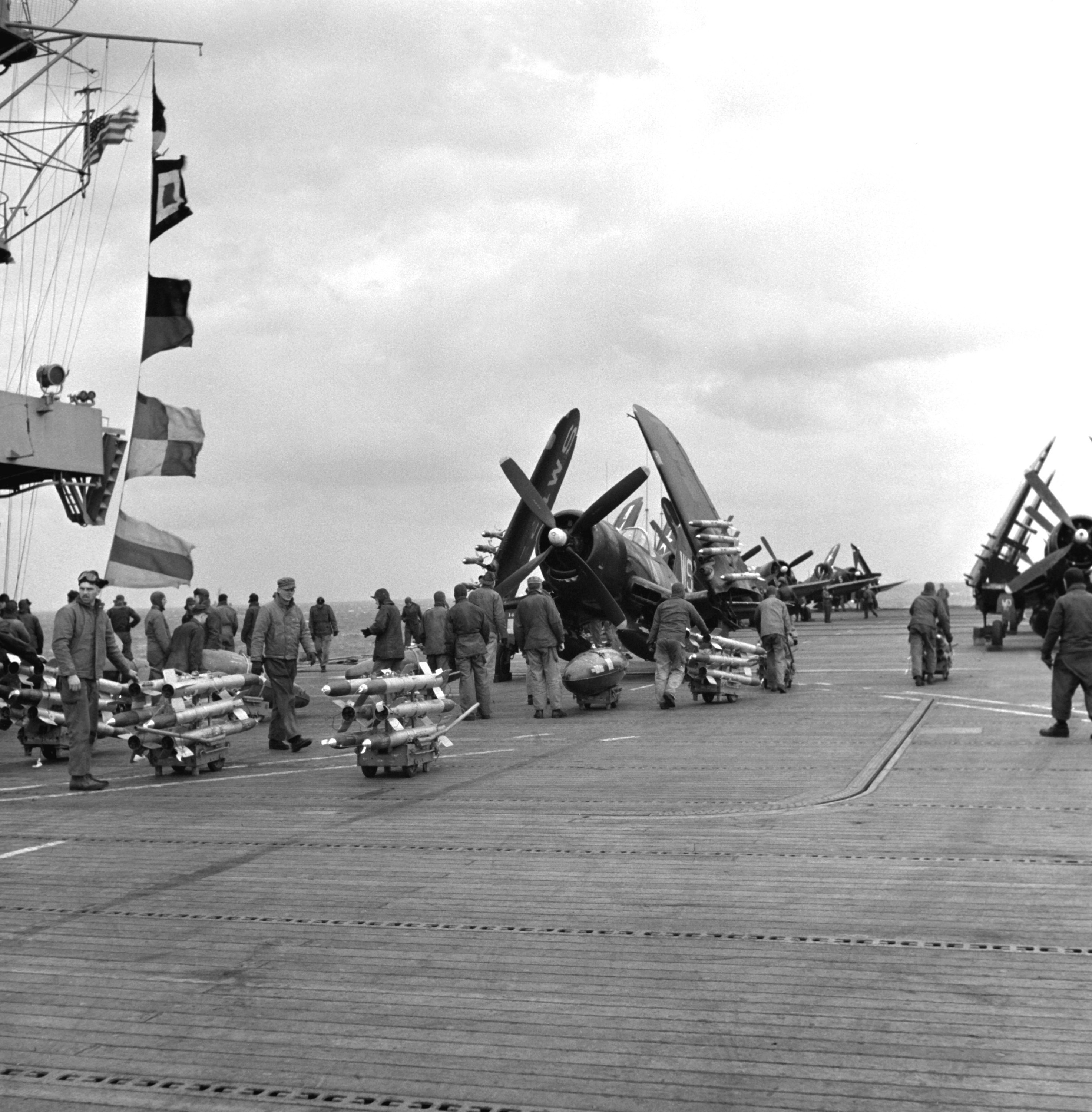 VMF 323 USN ordnance personnel loading rockets and napalm aboard CVE 116 USS Badoeng Strait off Korea 01