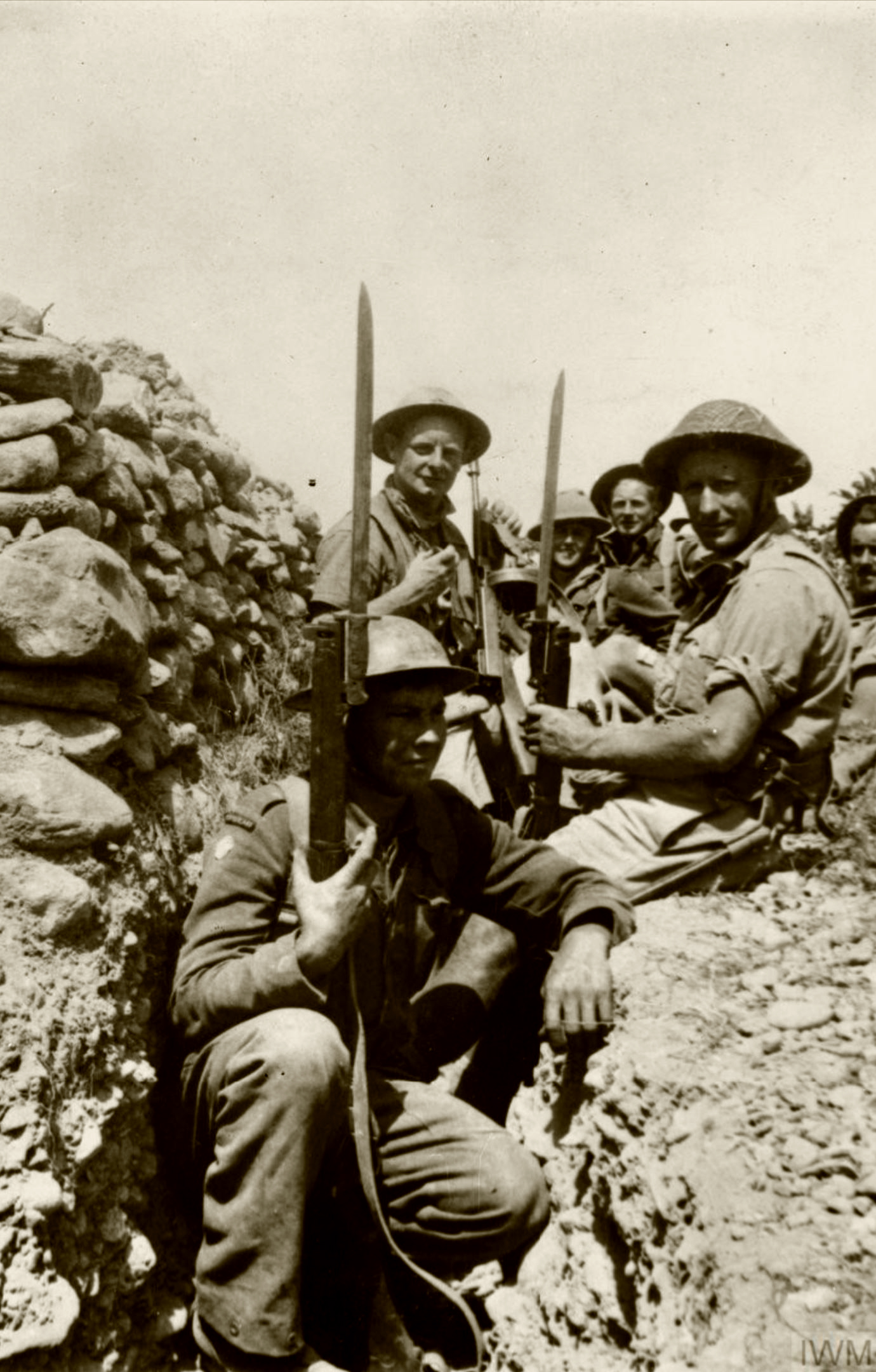 A group of British soldiers in a trench with fixed bayonets IWM E3025E
