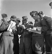 Asisbiz Aircrew Luftwaffe SG3 pilots study their maps at Immola for their next mission 2nd Jul 1944 03
