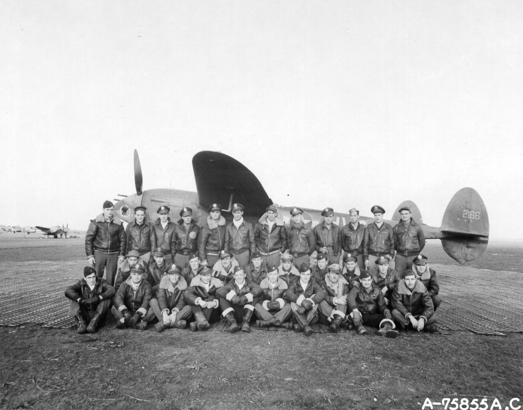 A group photo of 1FG94FS pilots posing against a Lockheed P-38 Lightning based in Italy 1944 45 02