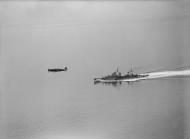 Asisbiz Spitfire RAF 93Sqn HNA flying over HMS Argonaut during Operation Torch 1942 IWM A11050