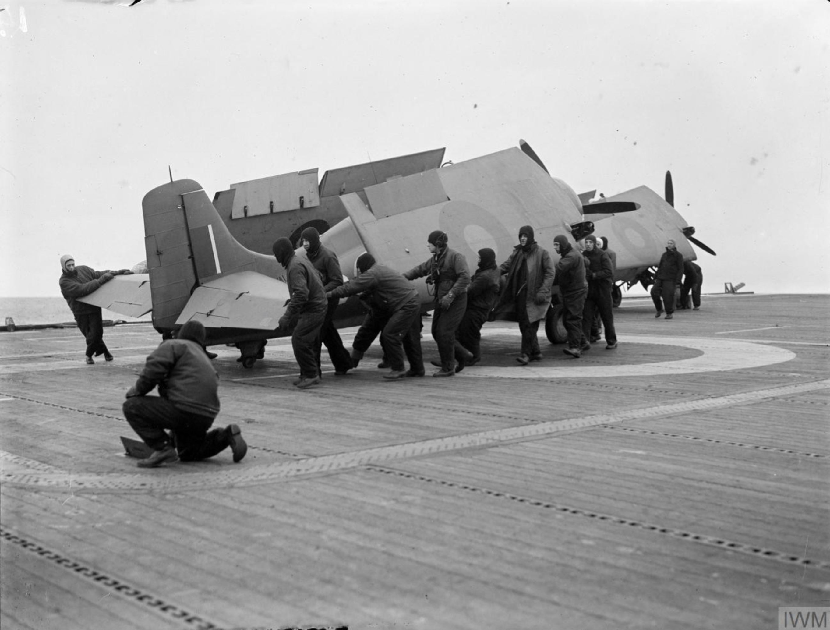 Fleet Air Arm Martlets aboard HMS Pursuer being manhandled on to the lift to be carried below 1944 IWM A23062