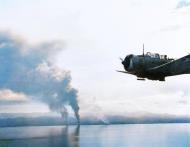 Asisbiz Japanese transports burn at Guadalcanal as an SBD bomber flies by Guadalcanal Campaign 16th Nov 1942 80 G 30517