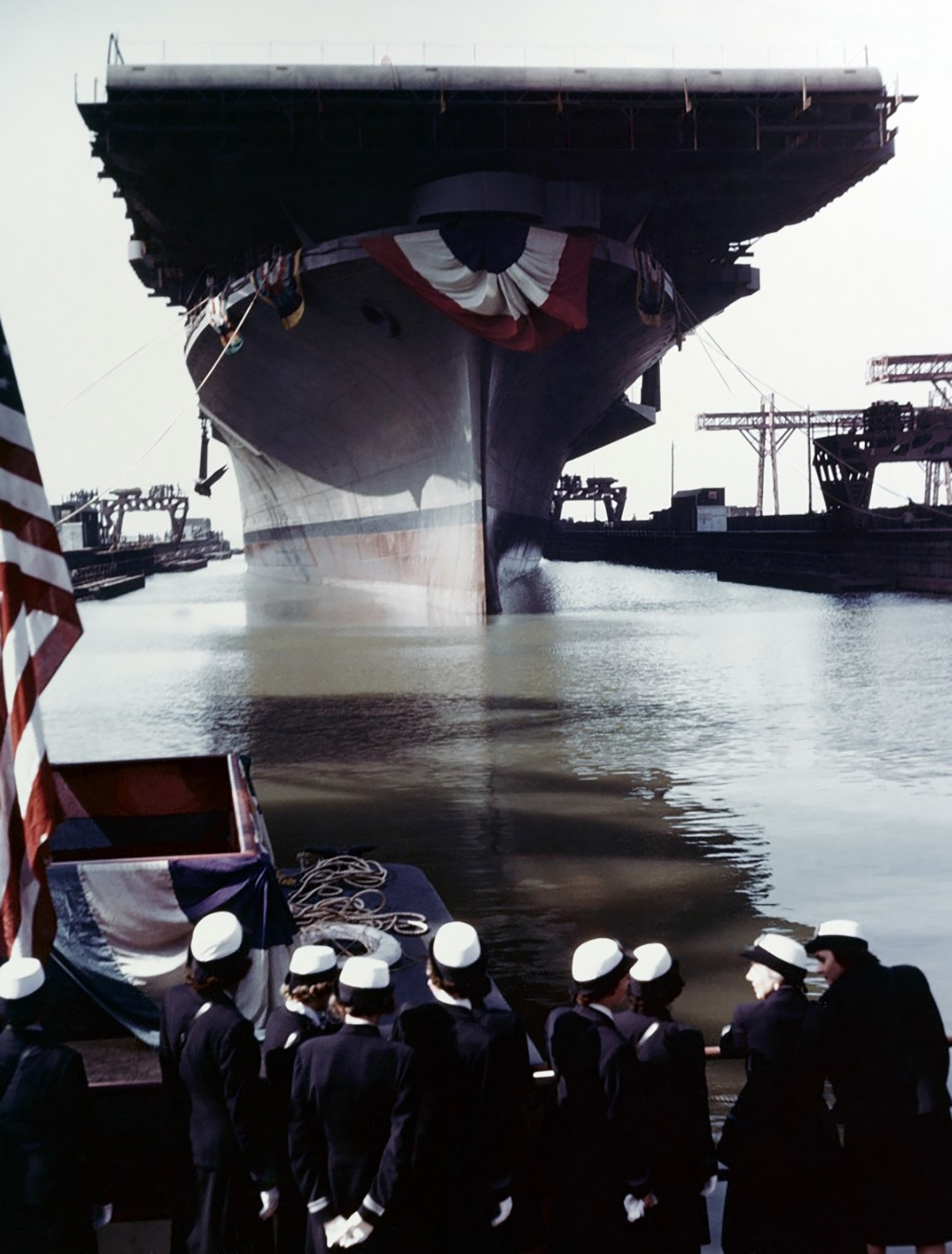 Asisbiz Franklin is floated out of her building dock following her christening at the Newport News Shipbuilding & Dry Dock Company shipyard, Newport News, on 14 October 1943. Note the WAVES officers in the foreground.