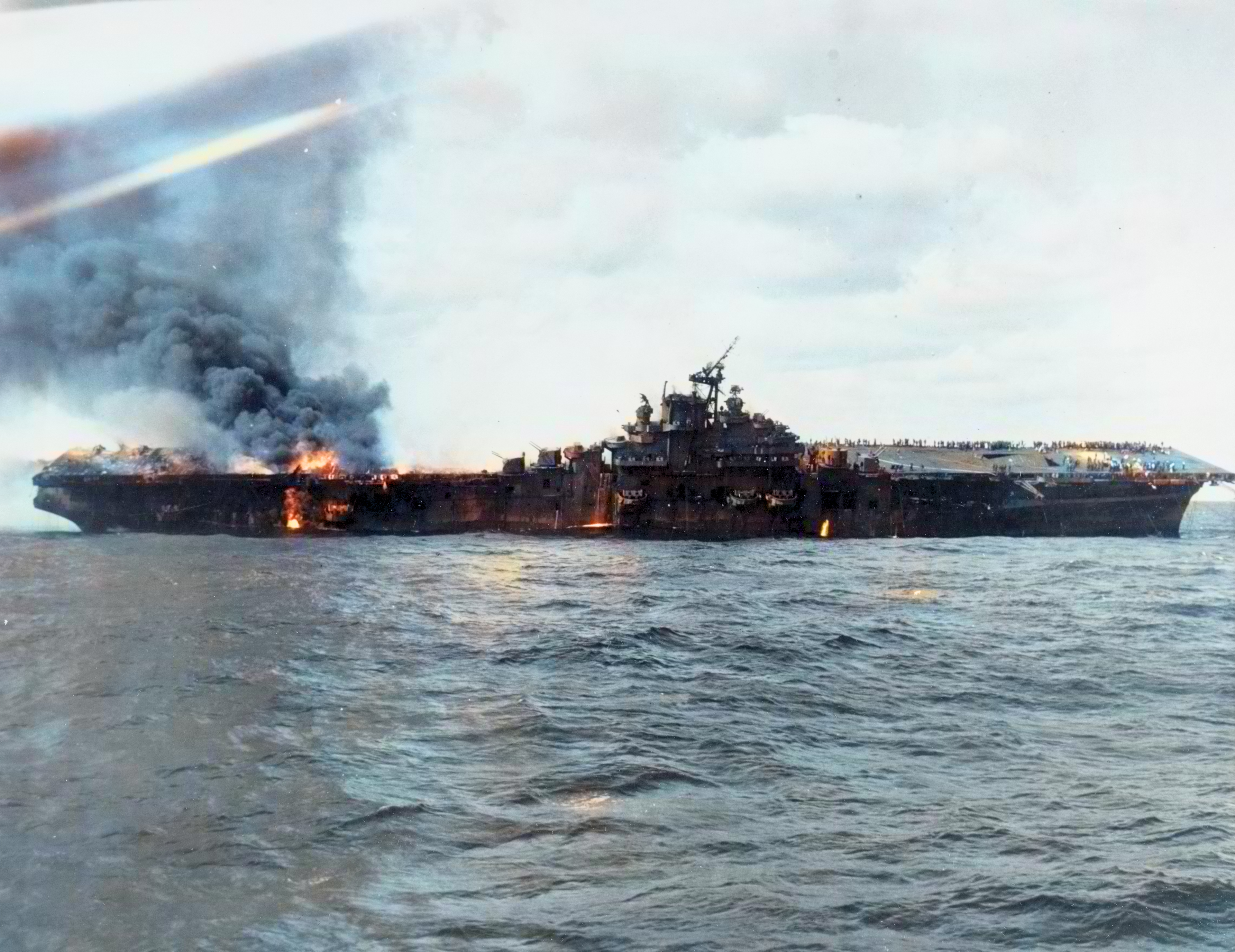 USS Franklin (CV 13) hit by bombs from a Japanese aircraft viewed from USS Santa Fe (CL 60) 19th Mar 1945 80 G 273894