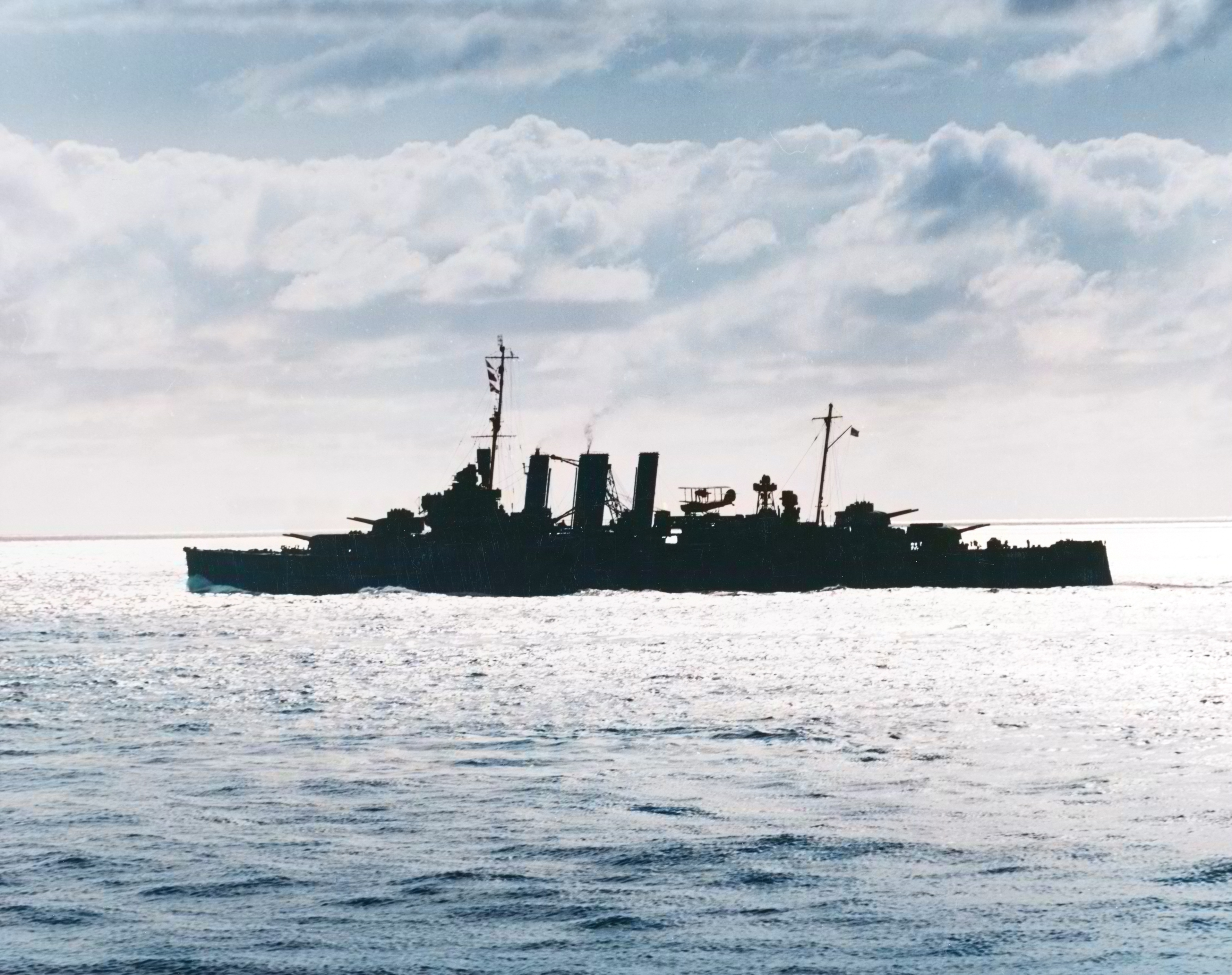 Australian heavy cruiser HMAS Australia silhouetted against the sun at sea in the south Pacific 4th Aug 1943 80 G 78946
